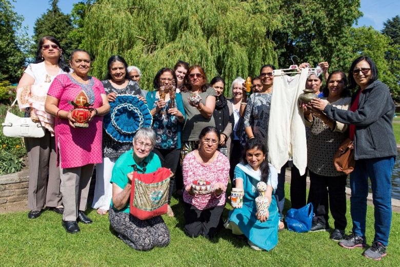 Anand Mangal ladies stood outside and holding up treasured items