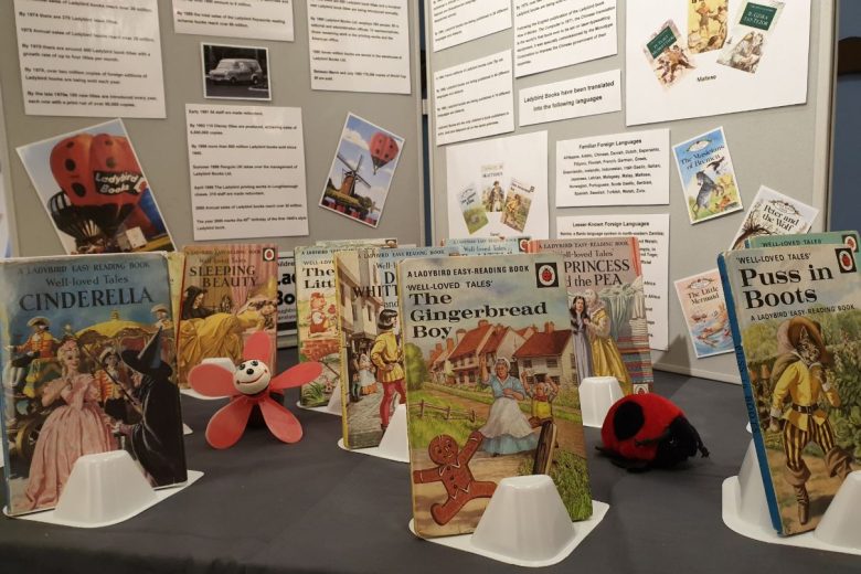Exhibition panel with old ladybird books displayed in front.