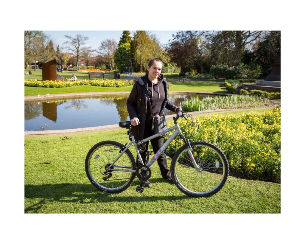 Photo of Catherine with her bike in a park