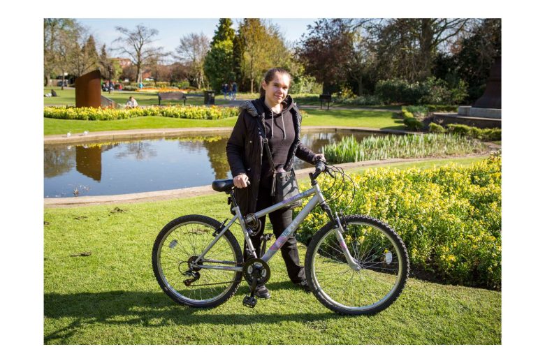 Photo of Catherine with her bike in a park