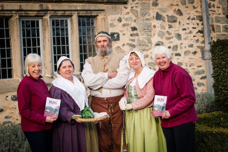 A group of volunteers stood outside. some are in period costumes.