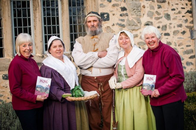 Five volunteers stood outside the house. some are in period costumes.