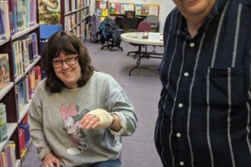 Woman holding up her hand that is wrapped in a bandage