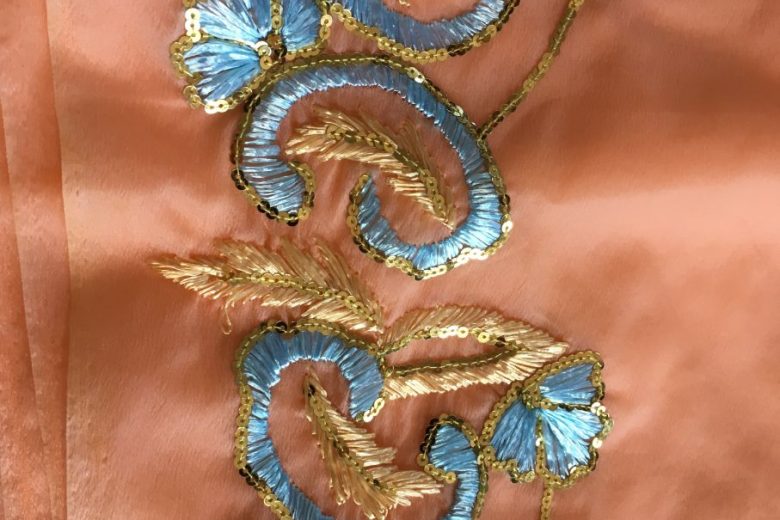Details on a peach and blue coloured sari