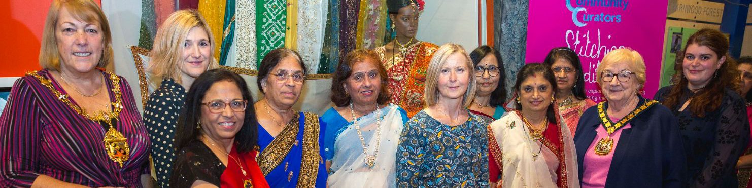 Anand Mangal ladies participation workers and the mayor stood in front of a wall of fabrics.