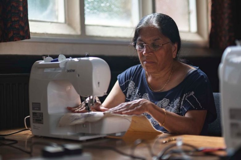 Anand Mangal lady sewing with her machine.