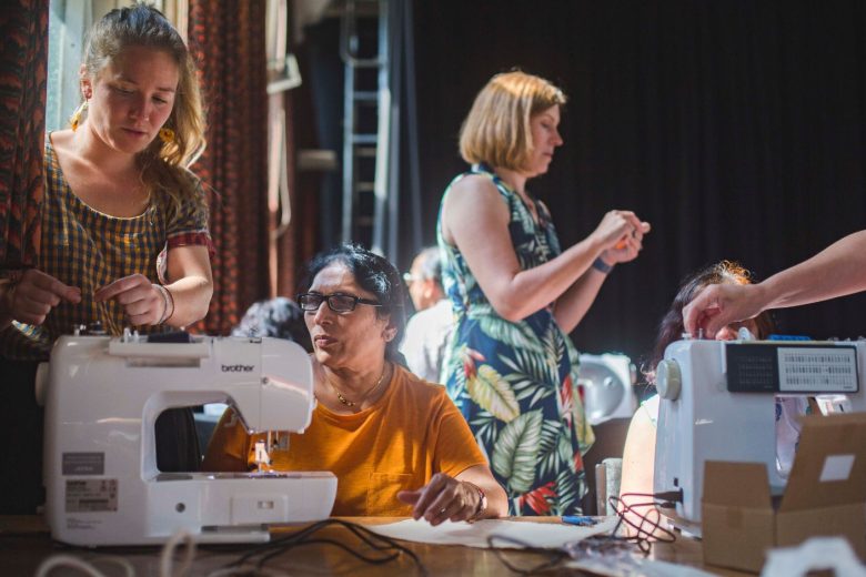 Workshop leaders helping the ladies thread their sewing machines