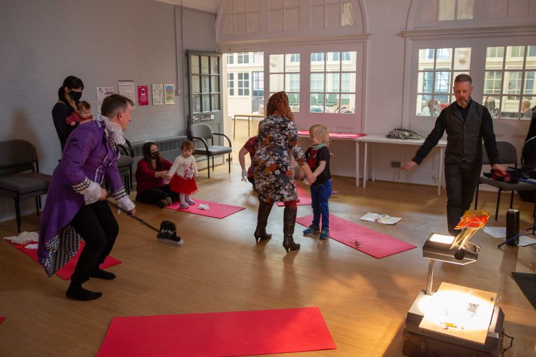 Performers, adults and children sat down, stood up or dancing.