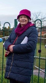 Linda wearing a winter jacket and a matching hat and scarf.