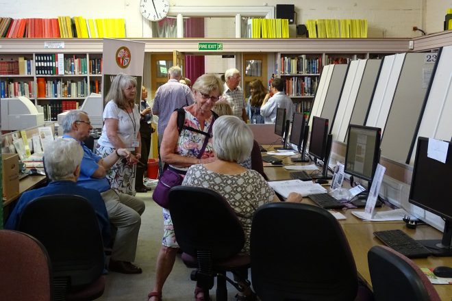 Record office with volunteers sat at computers or walking around