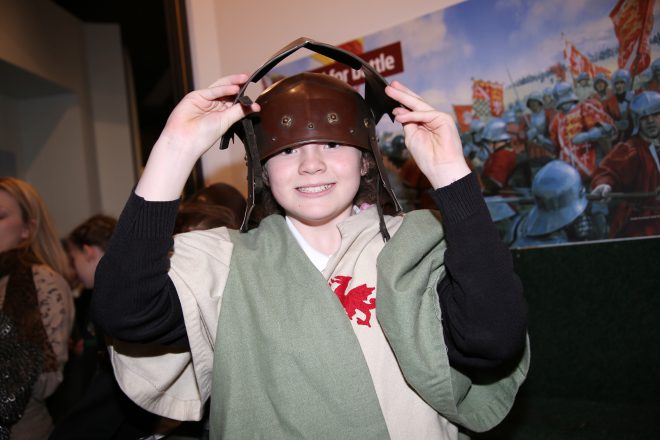 Child wearing a costume tunic and soldier's helmet