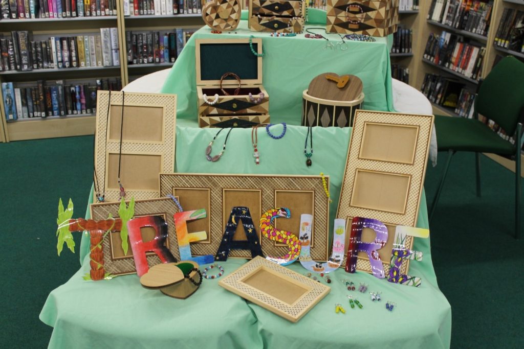 Artistic display based on the book Treasure Island featuring wooden frames and treasure boxes