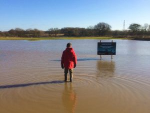 Person stood in a flooded meadow