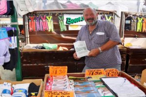 Man stood smiling behind the Boon's socks market stall