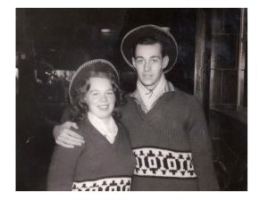 Black and white photo of a young Mike and his wife Marj. They're wearing matching knitted jumpers and matching hats.