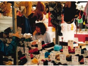 Woman sat at her stall which sells slippers