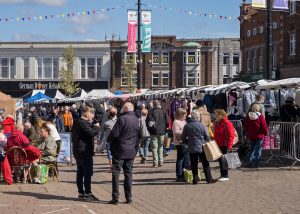 Loughborough market stalls. People shopping and chatting.