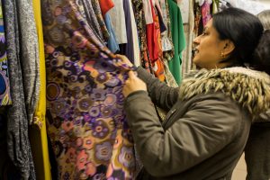 Lady looking through a rail of patterned fabrics