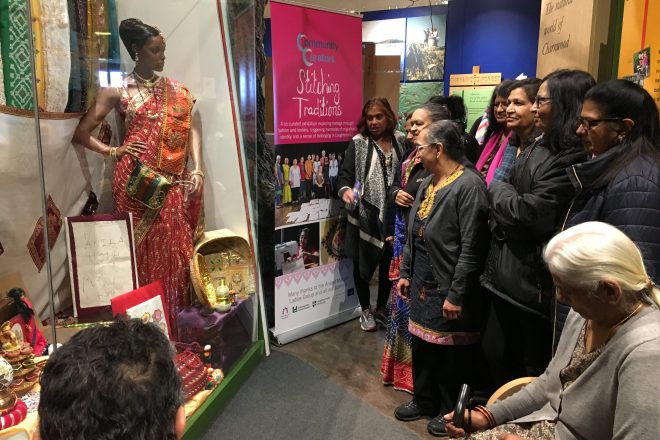 Anand Mangal ladies looking at a sari in a display case