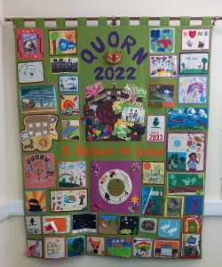 Large textile wall hanging featuring all the handmade patches. Quorn 2022: a stitch in time has been stitched onto it.