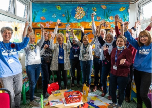 Library volunteers and participation team members smiling and raising their arms